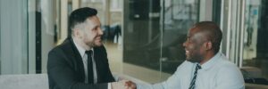 Executives shaking hands to close a deal